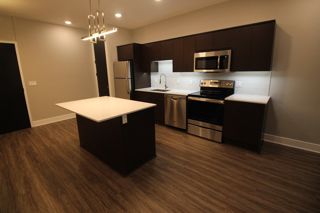 a kitchen with an island and a stove and a refrigerator