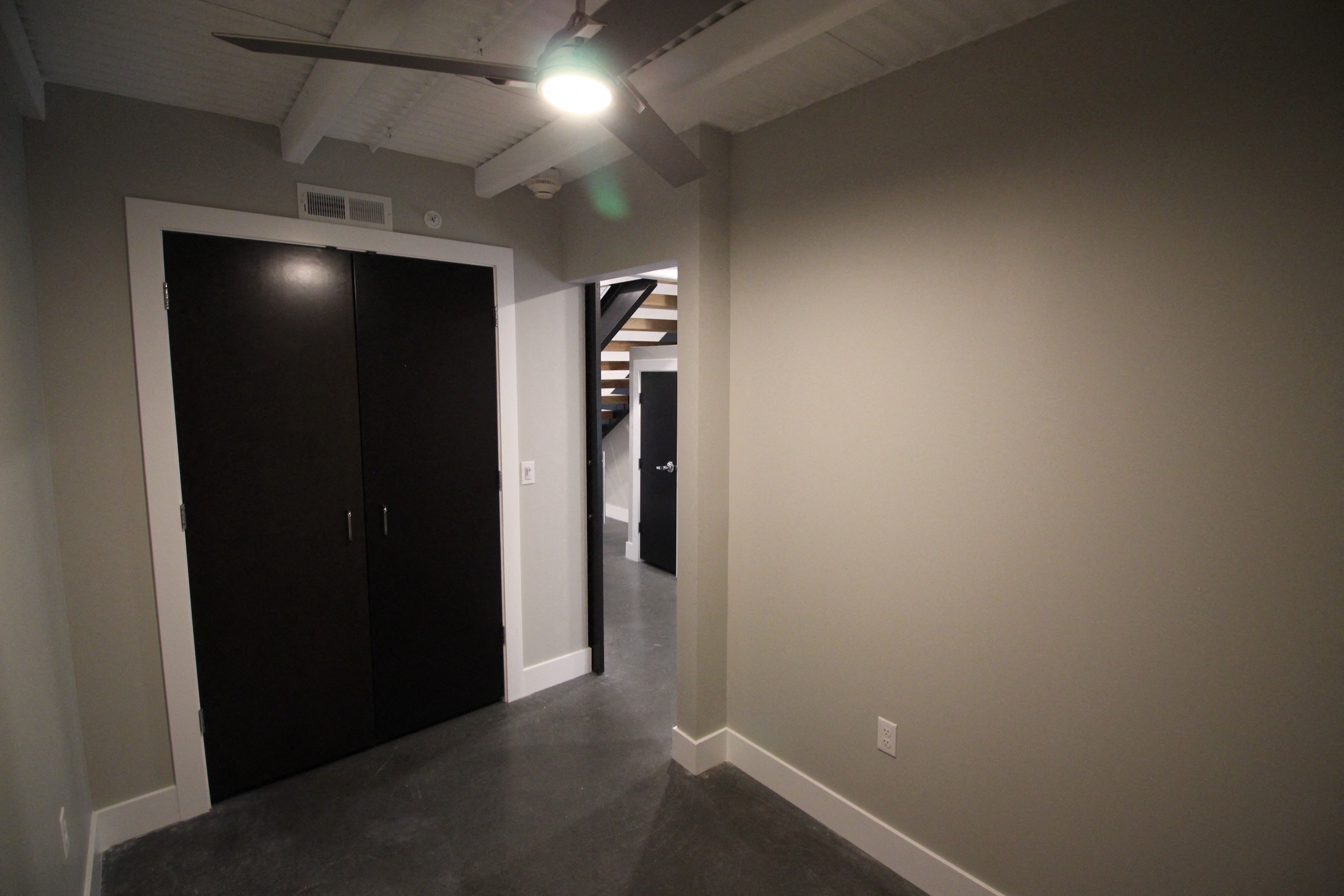 a hallway with two doors and a ceiling fan