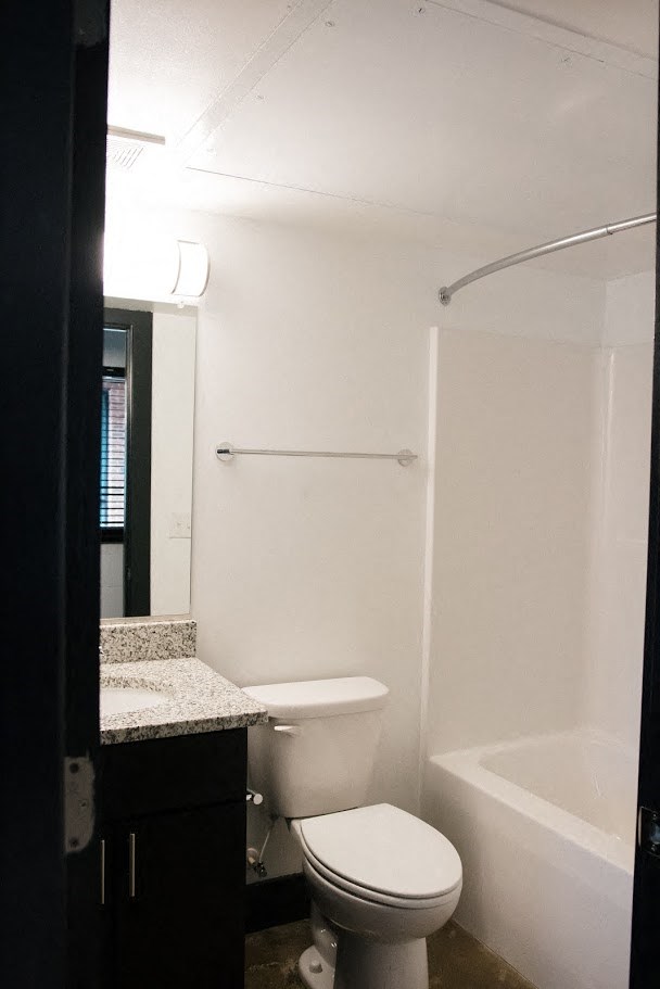 a white bathroom with a toilet and a tub