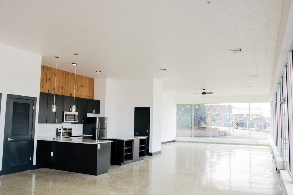 a large kitchen with black cabinets and a large window