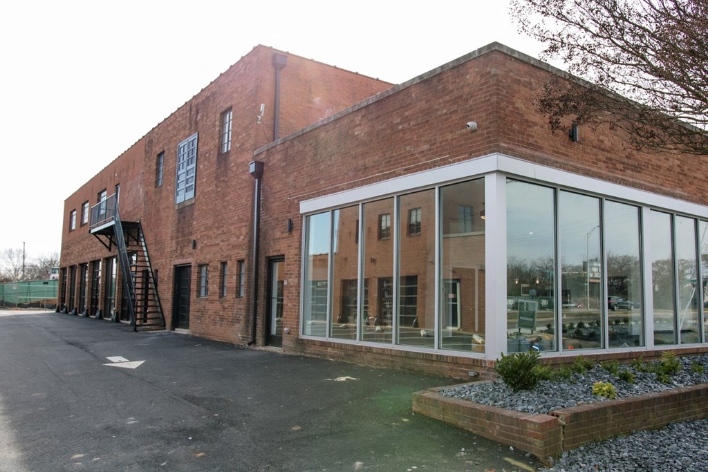 the front of a brick building with large windows