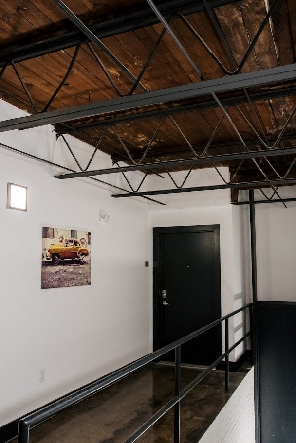 a room with a black door and a picture of a truck on the wall