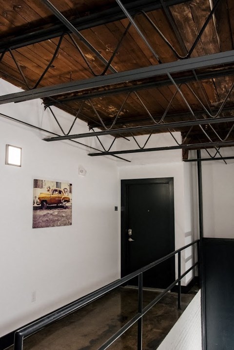 a room with a black door and a picture of a truck on the wall