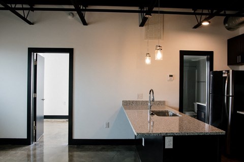 a kitchen with a granite counter top and a black refrigerator