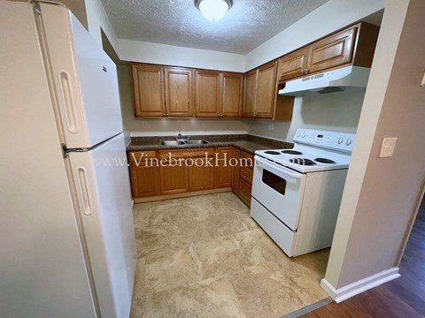 a small kitchen with white appliances and wooden cabinets