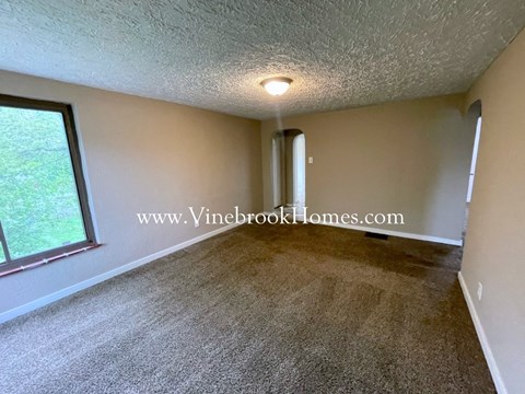 a large living room with carpet and a large window