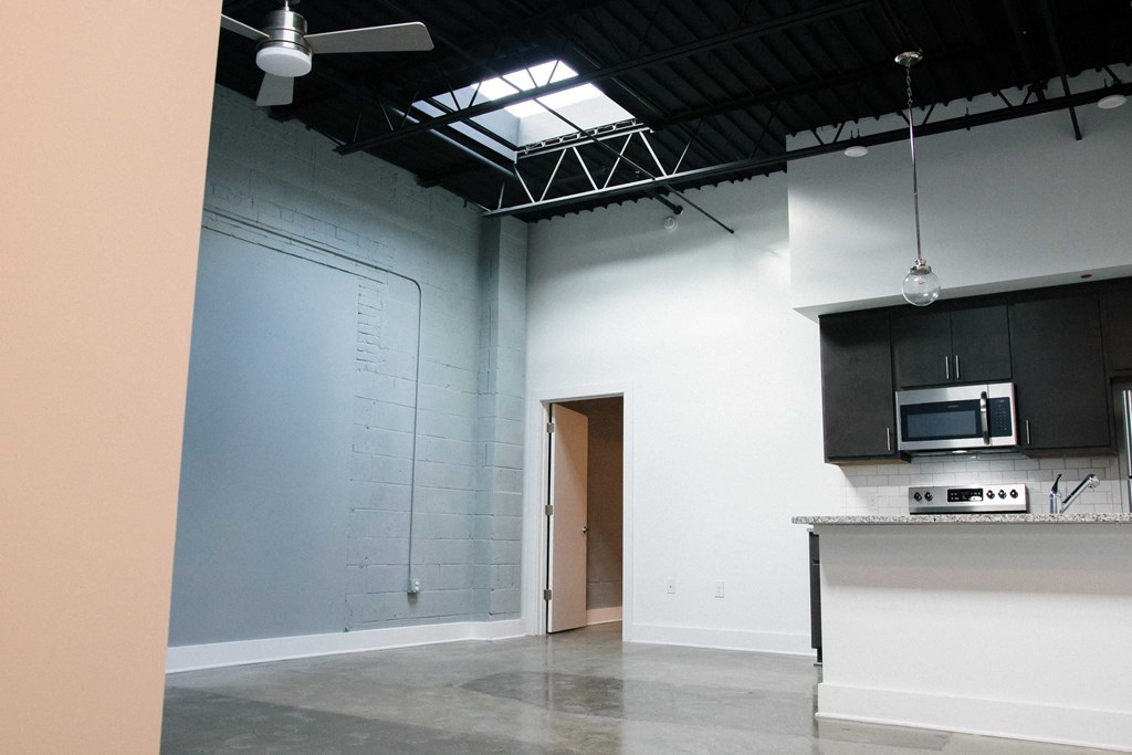 an empty room with a kitchen and a door to a closet