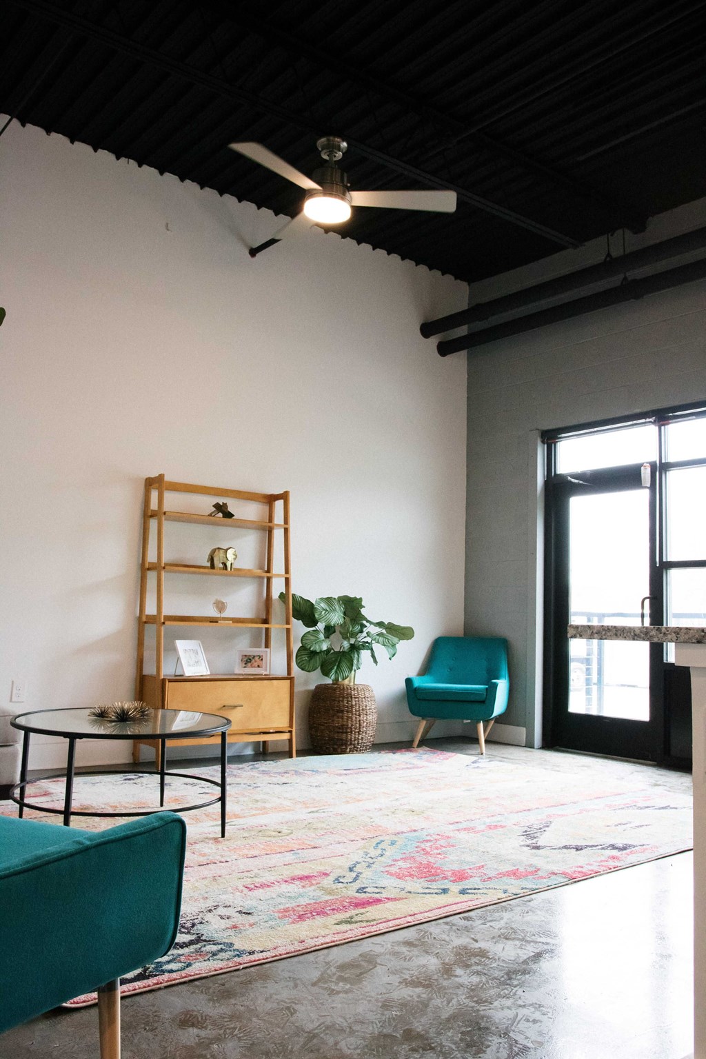 a living room with a rug and a ceiling fan