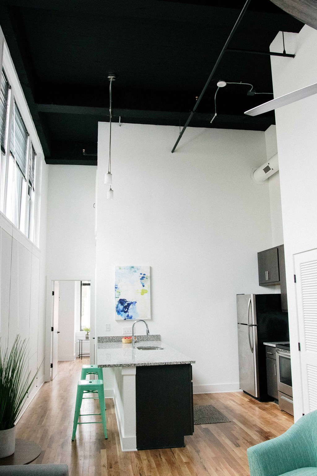 a kitchen and living room with a black ceiling and white walls