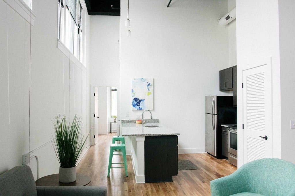 a living room with a kitchen and a chair and a table