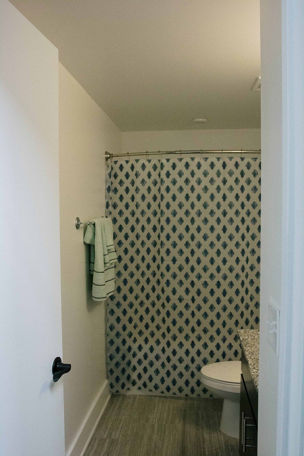 a small bathroom with a toilet and a tiled wall