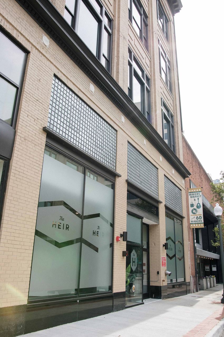 a brick building with a glass window on the side of a street