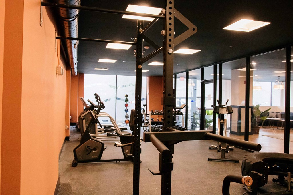 a gym with a lot of machines and mirrors in it