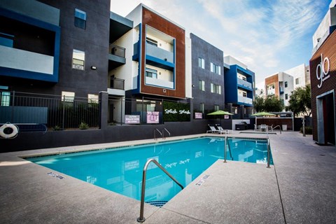 A swimming pool is surrounded by apartment buildings.