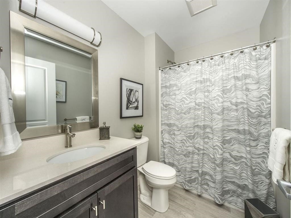 a bathroom with a shower and a toilet and a sink