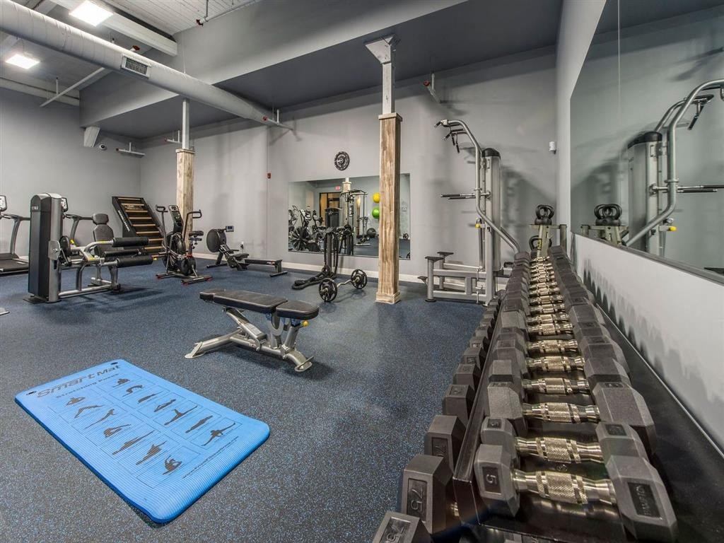 a gym with a row of benches and weights on the floor