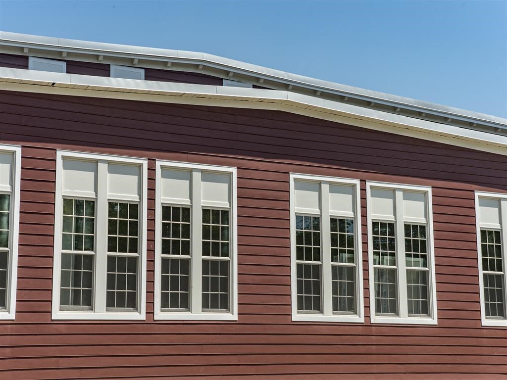 a row of windows on the side of a red house