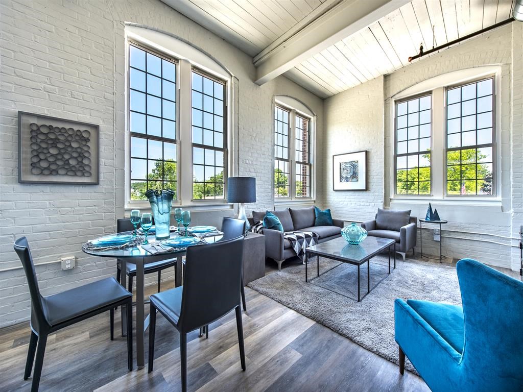 a living room with large windows and a table and chairs