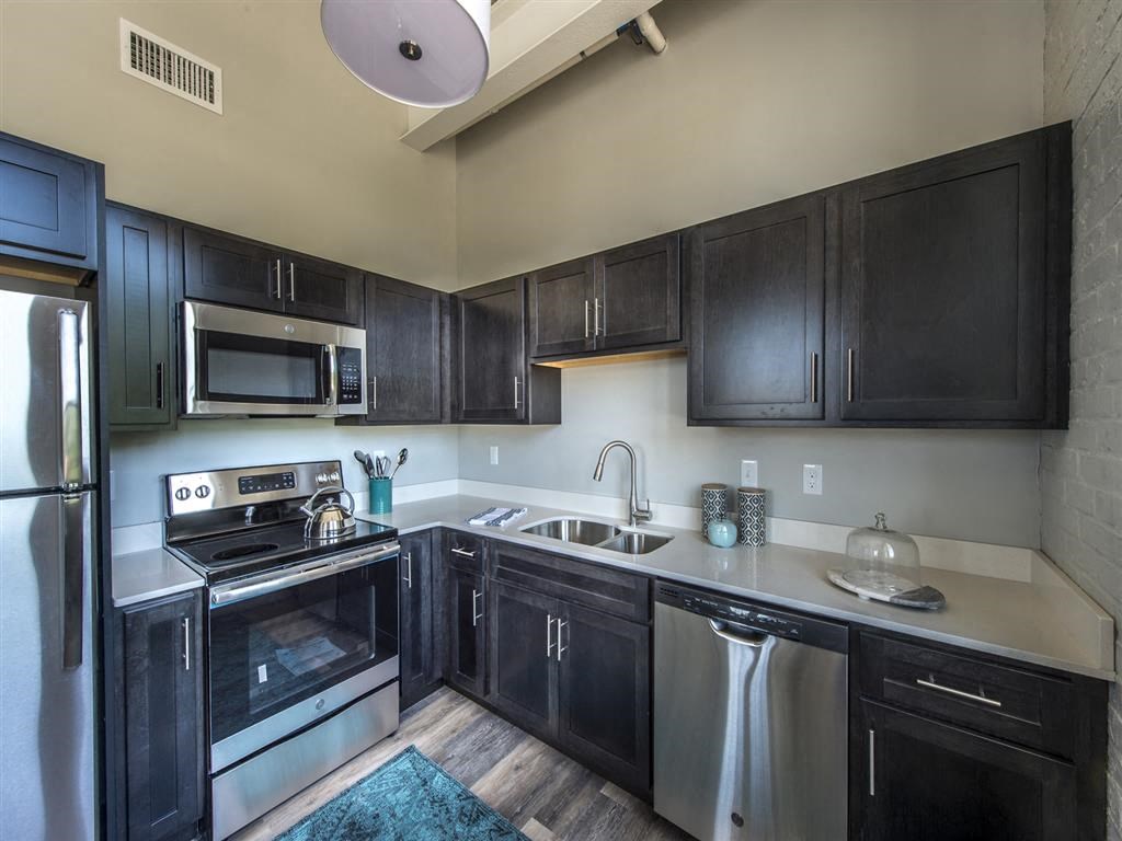 a kitchen with black cabinets and stainless steel appliances