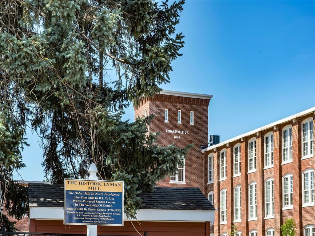 a building with a sign in front of a tree