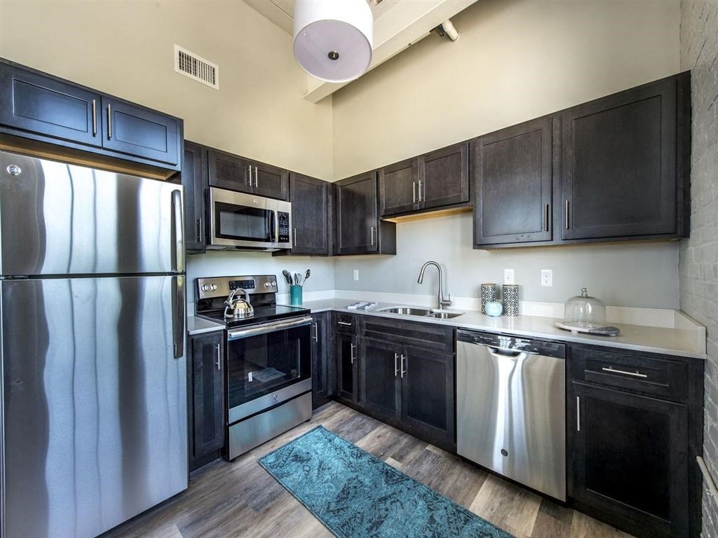 a kitchen with stainless steel appliances and black cabinets