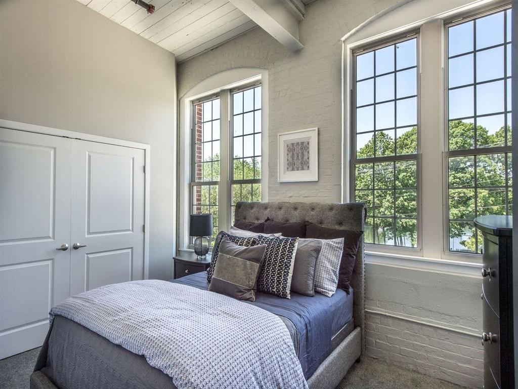 a bedroom with a bed and three windows