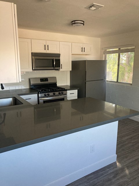 A kitchen with a stove top oven and a refrigerator.