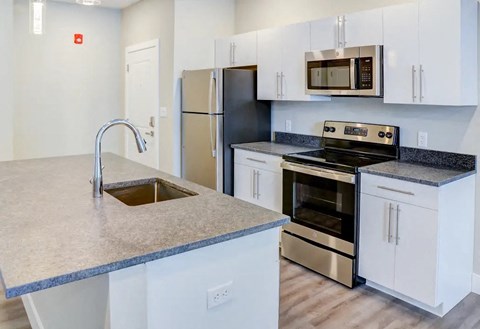 a kitchen with a sink and a stove and a refrigerator