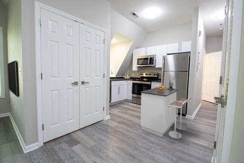a white kitchen with a stainless steel refrigerator