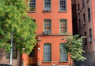 a red brick building with green windows and trees