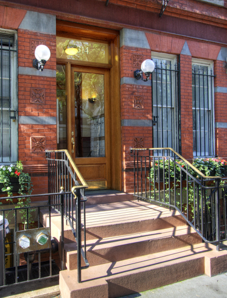 the front of a building with stairs and a door