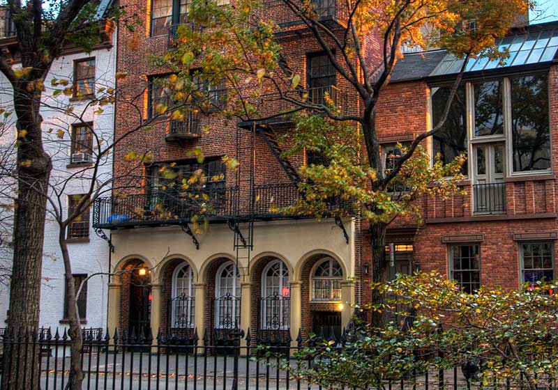 a red brick house with a wrought iron fence
