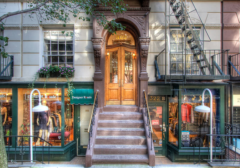 a staircase in front of a building with a brown door