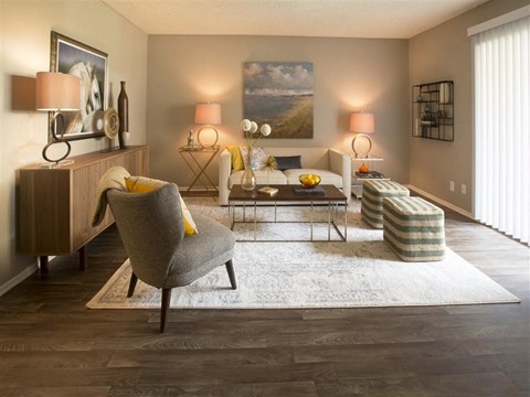 A living room with a grey chair and a white rug.