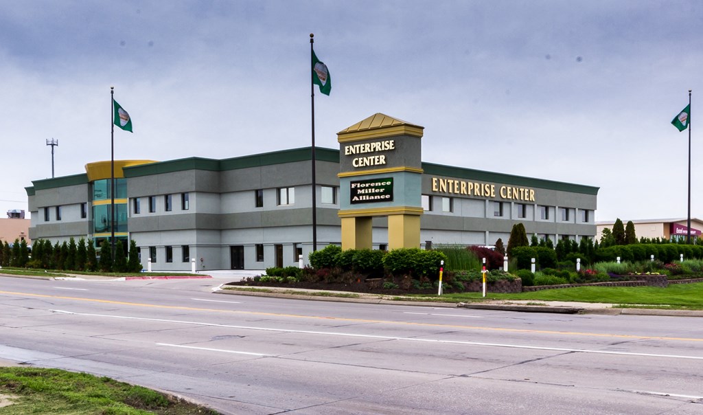 A large grey building with a yellow roof and a sign that says Enterprise Center.