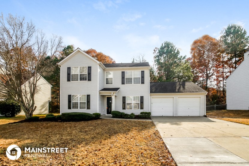 a white house with a yard and a white garage