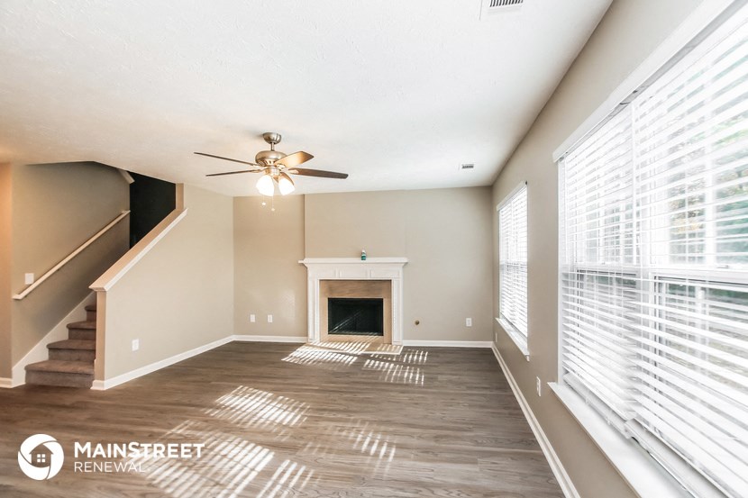 a living room with a fireplace and a ceiling fan