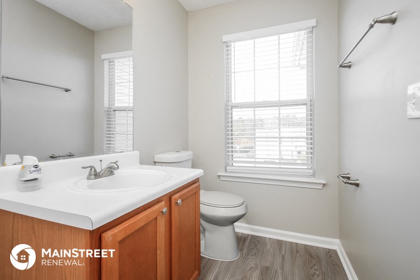 a bathroom with a sink and a toilet and a window