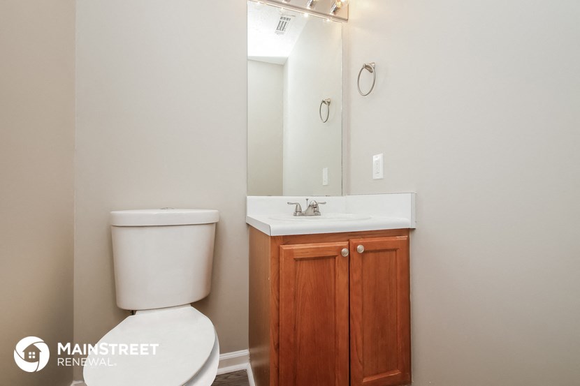 a bathroom with a toilet and a sink and a mirror