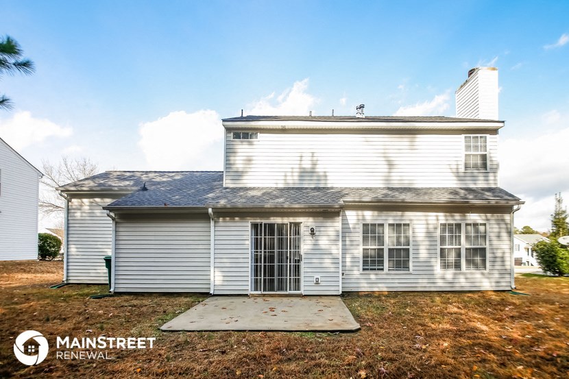 a small white house with a garage and a porch