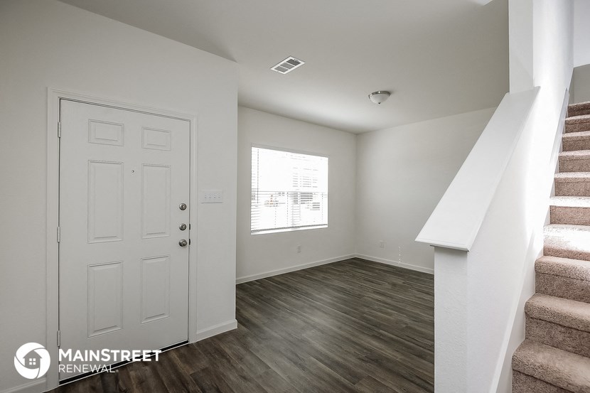 a living room with a staircase and a white door