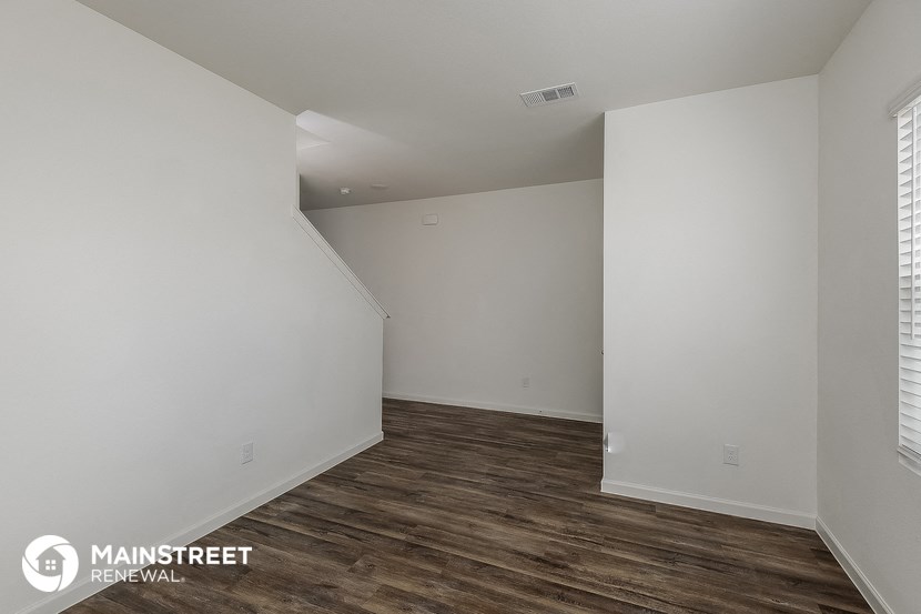 a living room with white walls and wood flooring