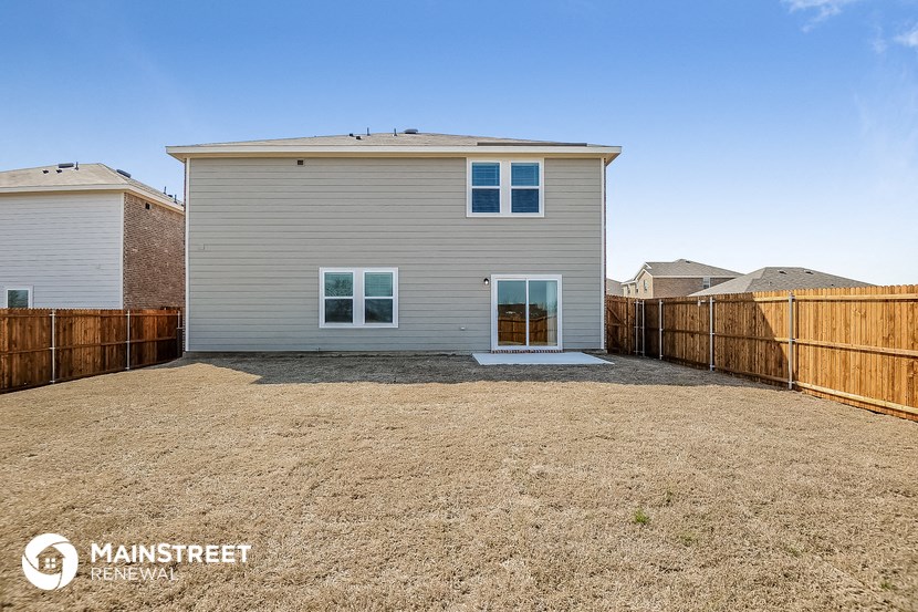 a white house with a yard and a wooden fence