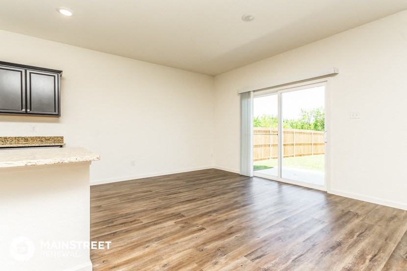 an empty living room with a sliding glass door to a patio