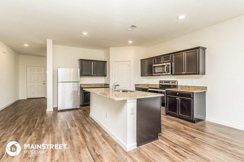 a kitchen with an island and a stove and a refrigerator