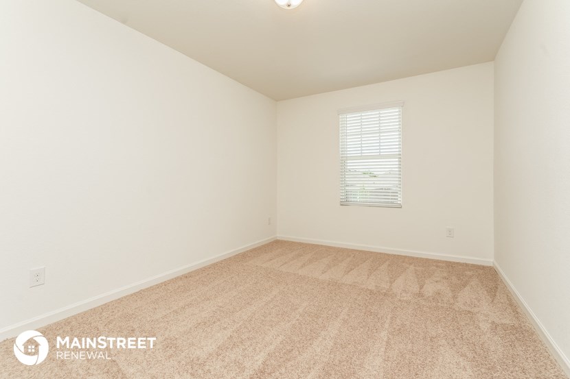the living room of a home with carpet and a window