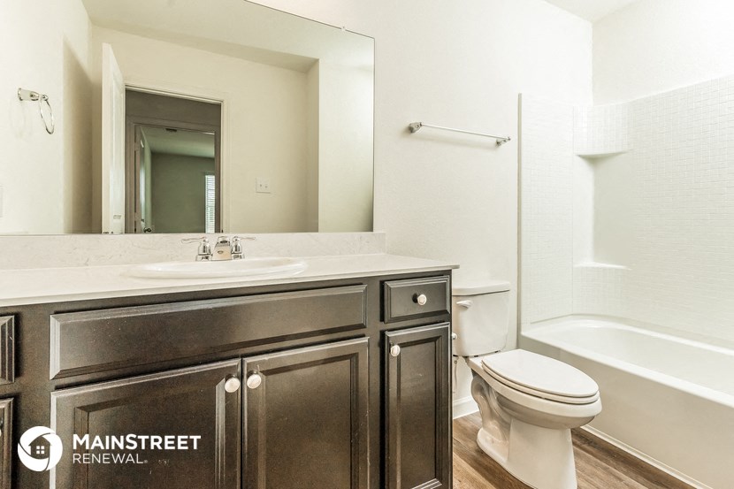 a bathroom with a sink toilet and a mirror