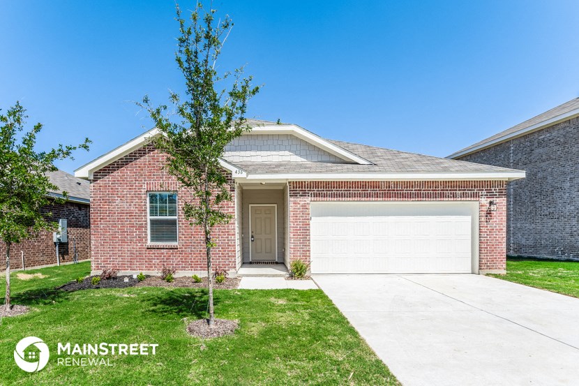 a brick house with a white garage door and a lawn