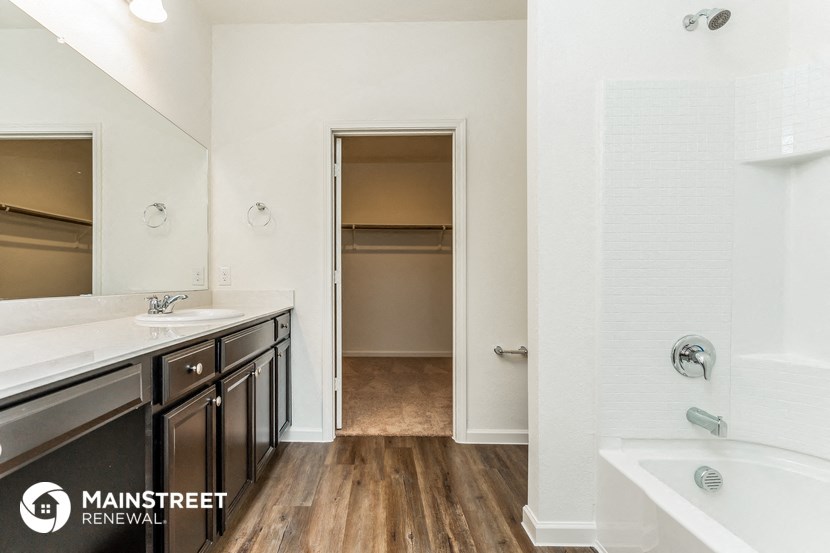 a bathroom with two sinks and a tub and a shower