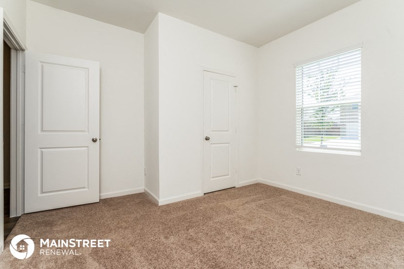 the upstairs bedroom with two doors and a window